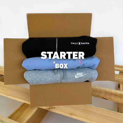 Starter Box | Vintagebulk met drie opgevouwen vintage hoodies van merken zoals Nike en Daily Paper in een open kartonnen doos, ideaal voor duurzame modegroothandel.