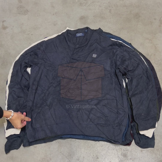 Gestapelde Chaps by Ralph Lauren vintage truien op betonnen vloer, ideaal voor duurzame mode wholesale via Vintagebulk.